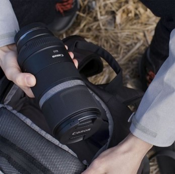 Canon RF 600mm F11 IS STM – εικόνα προϊόντος, με χέρι που κρατάει τον φακό
